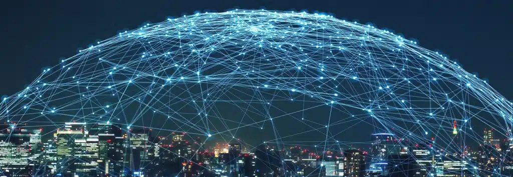 IoT network connectivity overlay on city skyline at night &ndash; representing business IoT solutions and smart device integration